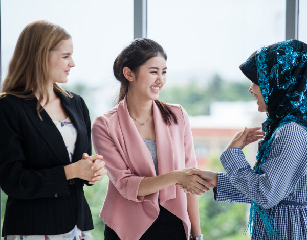 Happy three Business women Shaking Hands In Modern Office
