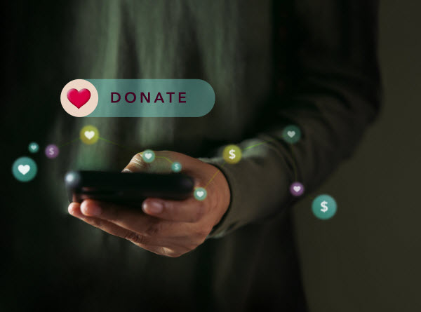 Man using a mobile phone with heart icon and donate text